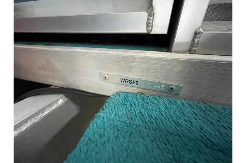 Slide: The Image of 1995 Weeres Fish 16 boat identification plate with serial number on teal carpet. - 18