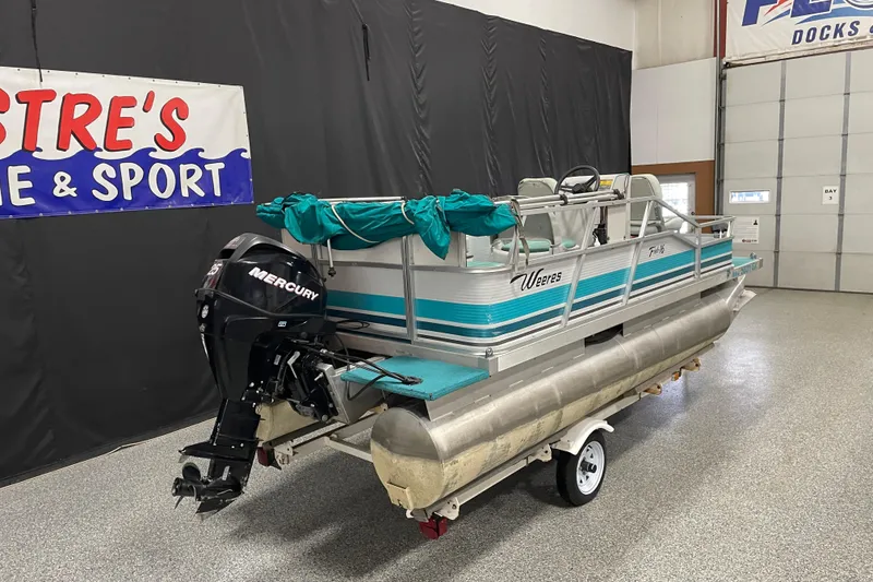 Slide: The Image of 1995 Weeres Fish 16 pontoon boat with Mercury outboard motor in showroom. - 3