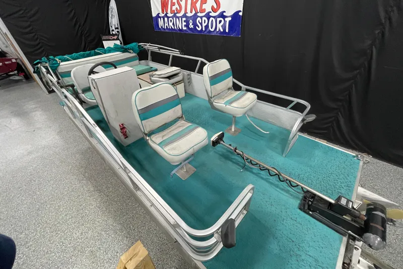 Slide: The Image of 1995 Weeres Fish 16 pontoon boat with teal interior and fishing seats. - 6