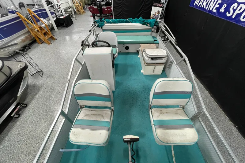 Slide: The Image of 1995 Weeres Fish 16 pontoon boat interior with teal and white seating. - 7