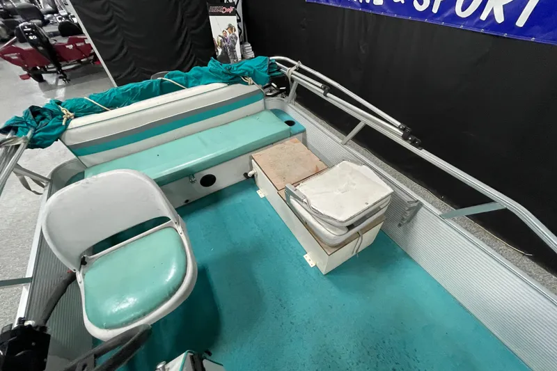 Slide: The Image of 1995 Weeres Fish 16 boat interior with teal seating and storage compartments. - 9