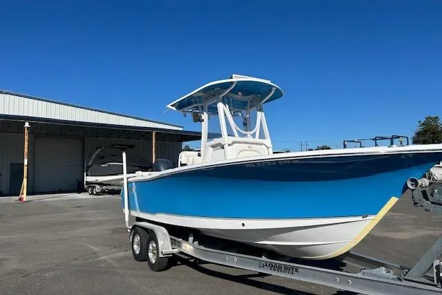 The Image of 2020 Sea Hunt Ultra 225 boat on trailer, blue hull, parked outdoors. - 1