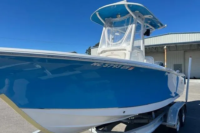Slide: The Image of 2020 Sea Hunt Ultra 225 boat on trailer, blue hull, parked outdoors. - 8