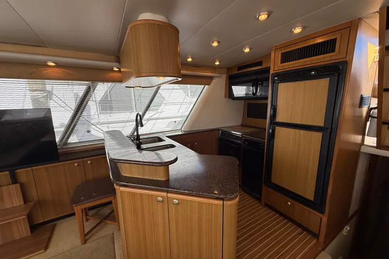 Slide: The Image of Interior of 2002 Bayliner 4788 Pilot House Motoryacht with modern kitchen and wood finishes. - 11