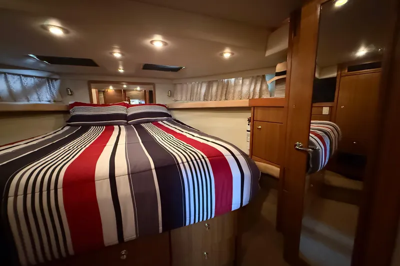 Slide: The Image of Luxurious bedroom in 2002 Bayliner 4788 Pilot House Motoryacht with striped bedding. - 21