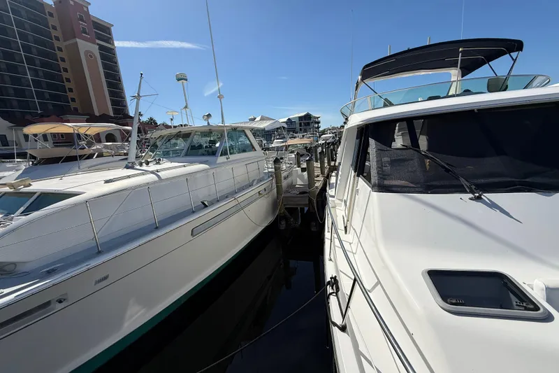 Slide: The Image of 2002 Bayliner 4788 Pilot House Motoryacht docked beside another yacht in marina. - 28