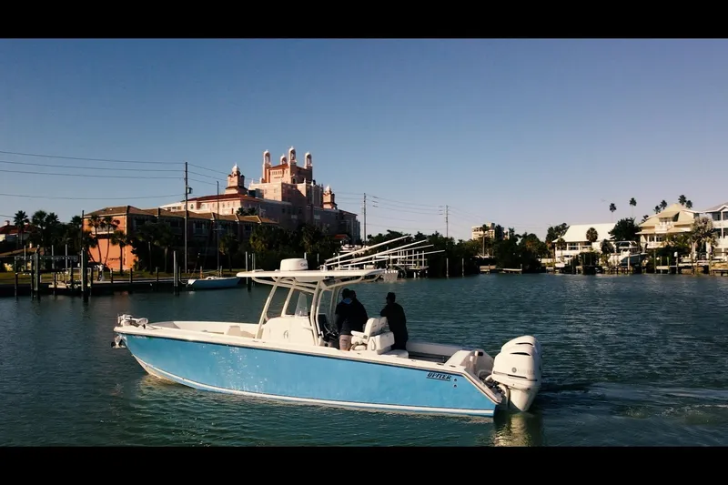 The Image of 2013 Jupiter 34 FS boat cruising near waterfront buildings under clear blue sky. - 1