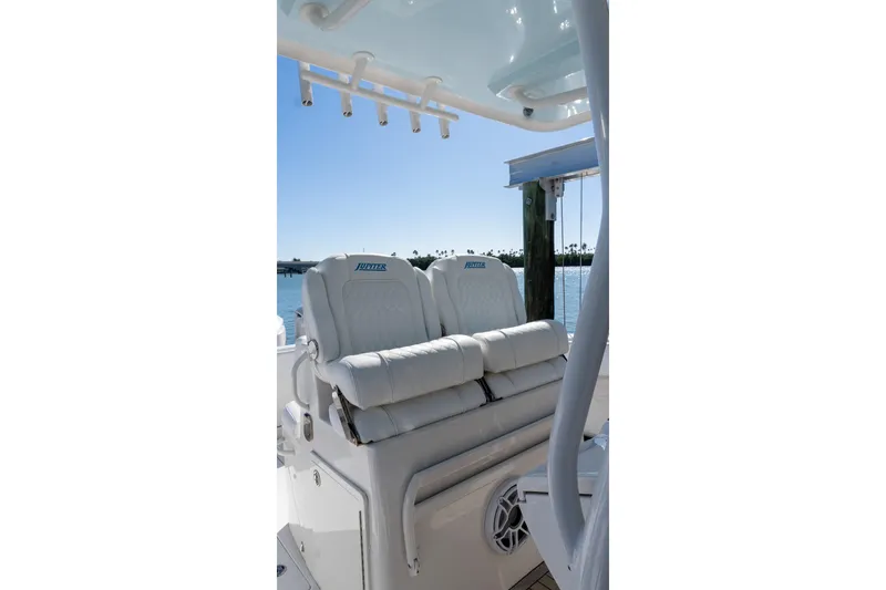 Slide: The Image of Luxury seating on 2013 Jupiter 34 FS boat, featuring plush white cushions and ocean backdrop. - 19