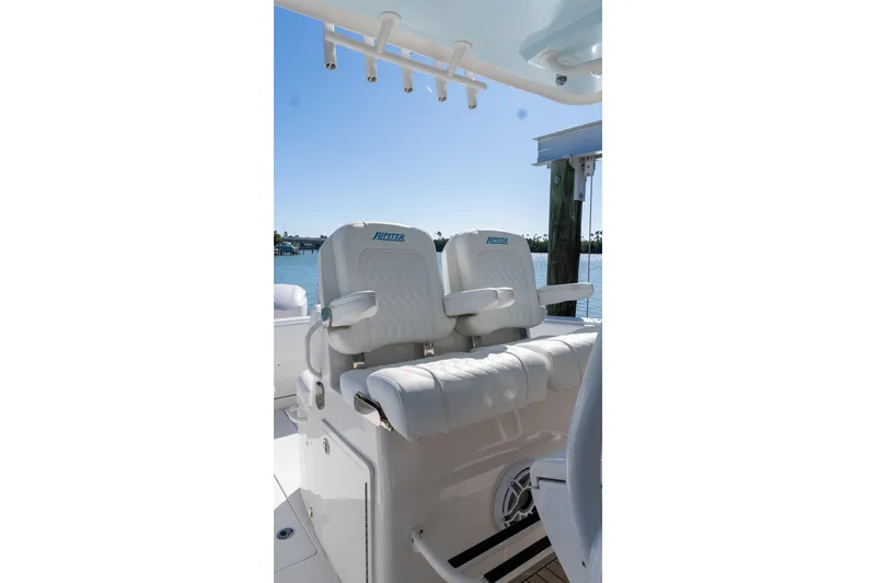 Slide: The Image of 2013 Jupiter 34 FS boat seats with armrests, docked by the water. - 20