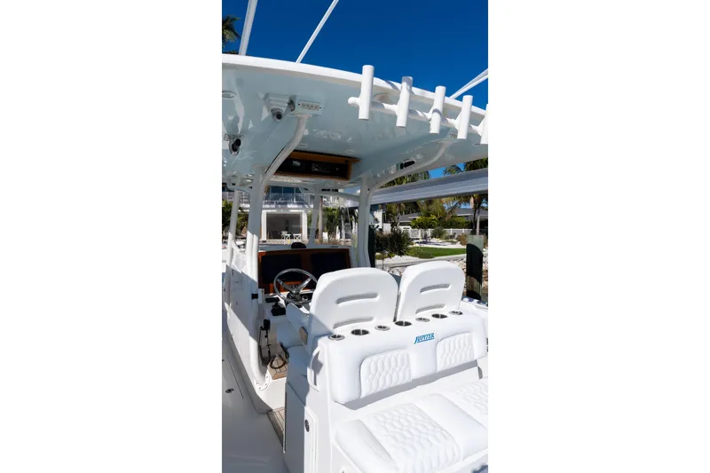 Slide: The Image of 2013 Jupiter 34 FS boat interior with helm and seating under clear blue sky. - 21