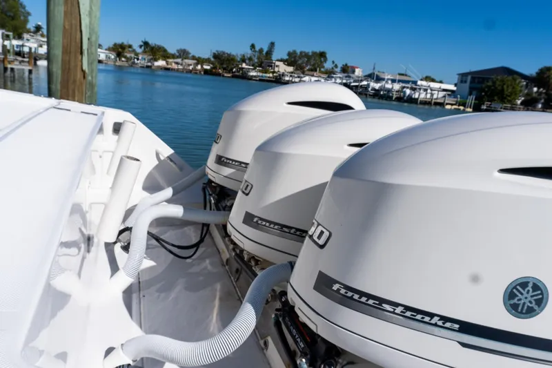 Slide: The Image of Triple outboard engines on a 2013 Jupiter 34 FS boat docked by the water. - 25
