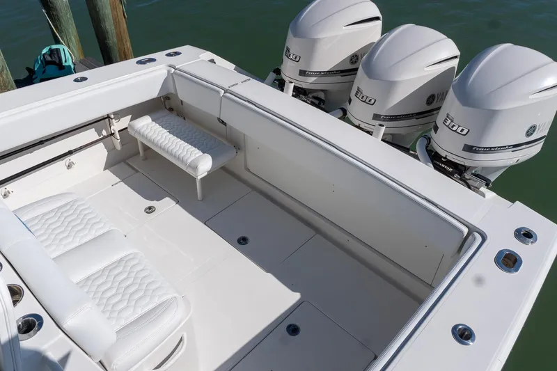 Slide: The Image of 2013 Jupiter 34 FS boat with triple Yamaha 300 engines, spacious deck, and white seating. - 26