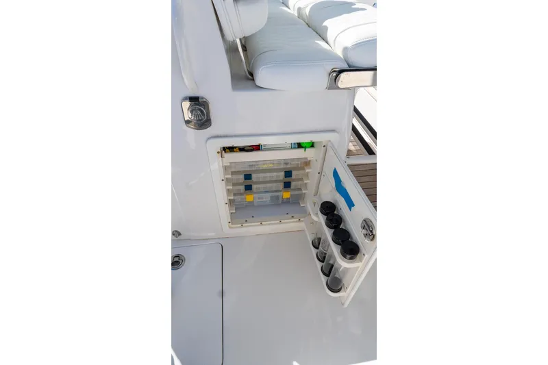 Slide: The Image of 2013 Jupiter 34 FS boat storage compartment with tackle boxes and cup holders. - 30