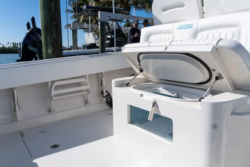 Slide: The Image of 2013 Jupiter 34 FS boat interior with open storage compartment, docked by the water. - 34