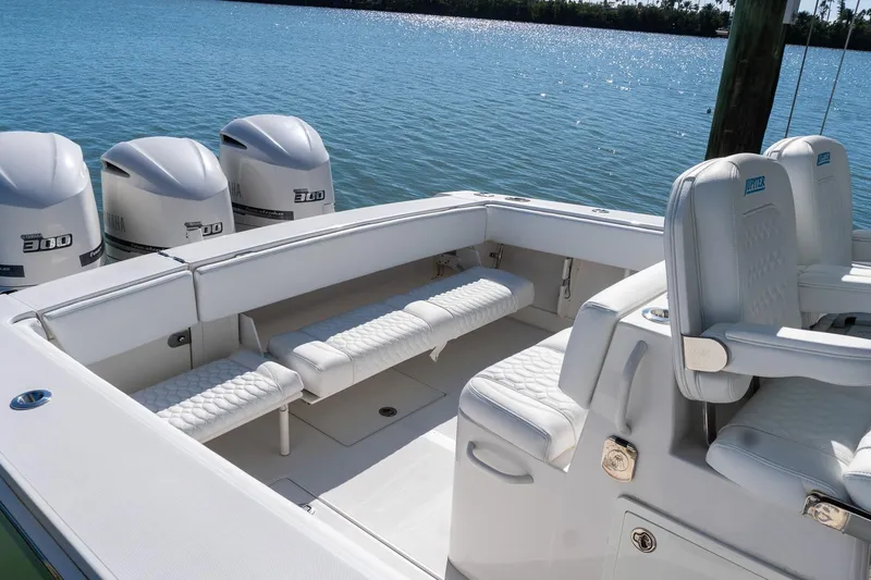 Slide: The Image of 2013 Jupiter 34 FS boat interior with Yamaha engines, featuring white seating and spacious deck. - 36