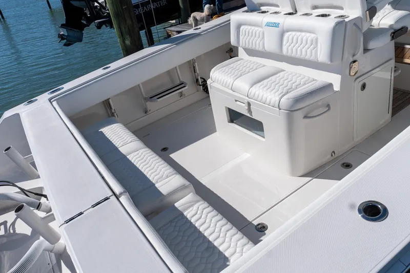 Slide: The Image of 2013 Jupiter 34 FS boat interior with white cushioned seating and storage. - 37