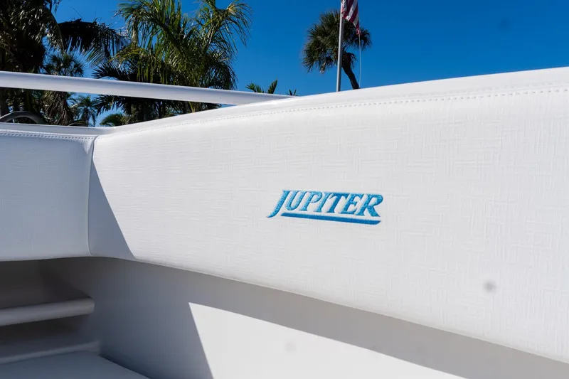 Slide: The Image of 2013 Jupiter 34 FS boat interior with logo, surrounded by palm trees and clear blue sky. - 42