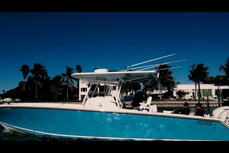 Slide: The Image of 2013 Jupiter 34 FS boat cruising near palm trees under clear blue sky. - 5