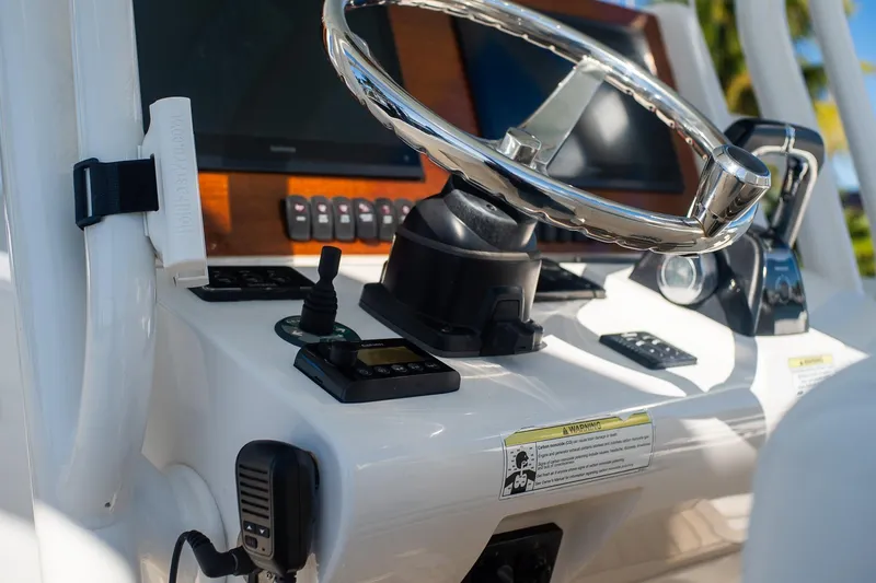 Slide: The Image of Control panel of a 2013 Jupiter 34 FS boat with steering wheel and navigation equipment. - 50