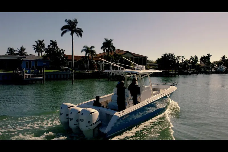 Slide: The Image of 2013 Jupiter 34 FS boat cruising on a scenic waterway with palm trees. - 6