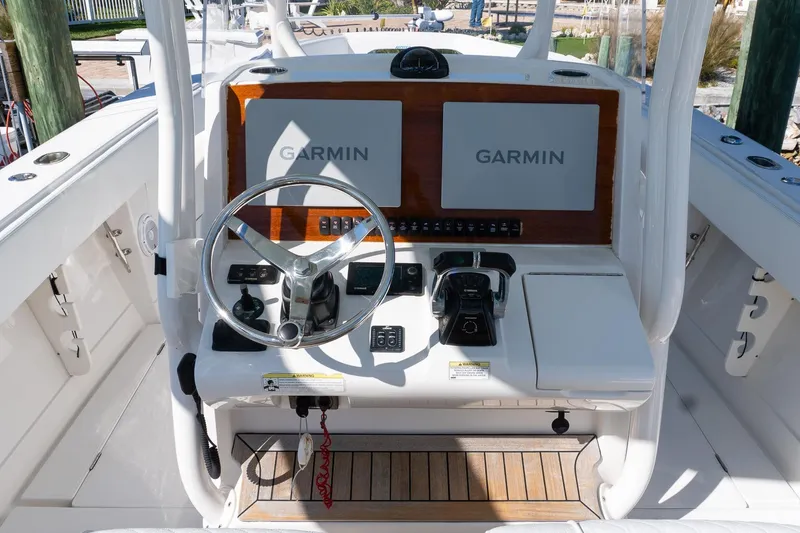 Slide: The Image of 2013 Jupiter 34 FS boat helm with dual Garmin displays and steering wheel. - 7