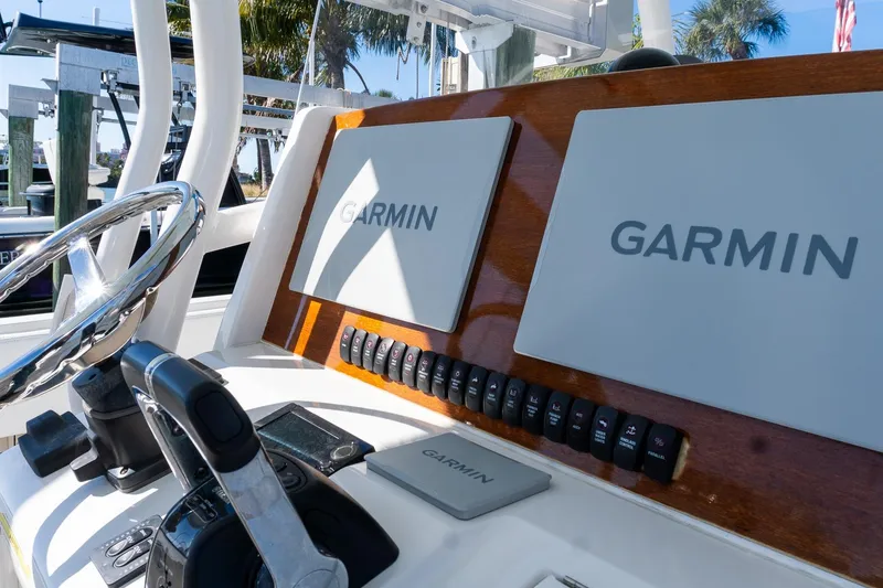 Slide: The Image of 2013 Jupiter 34 FS boat dashboard with Garmin navigation displays and controls. - 9