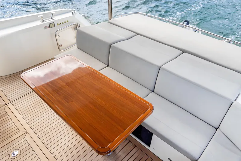 Slide: The Image of Luxurious seating area on 2019 Absolute 58 FLY yacht with wooden table and ocean view. - 8