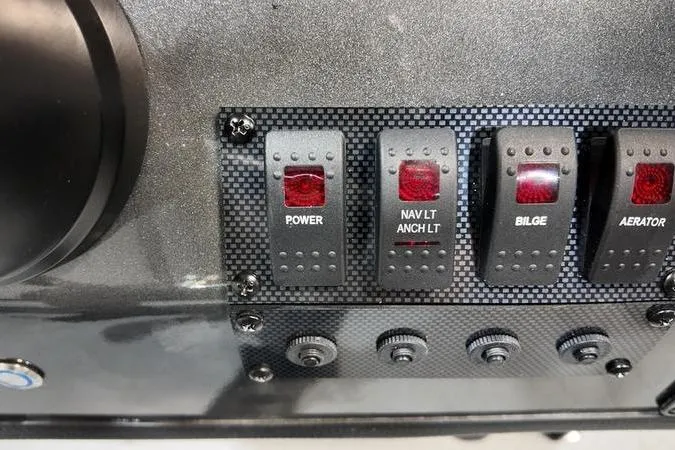 Slide: The Image of Control panel of 2025 SeaArk Shadow 18T boat with power, navigation, bilge, and aerator switches. - 11