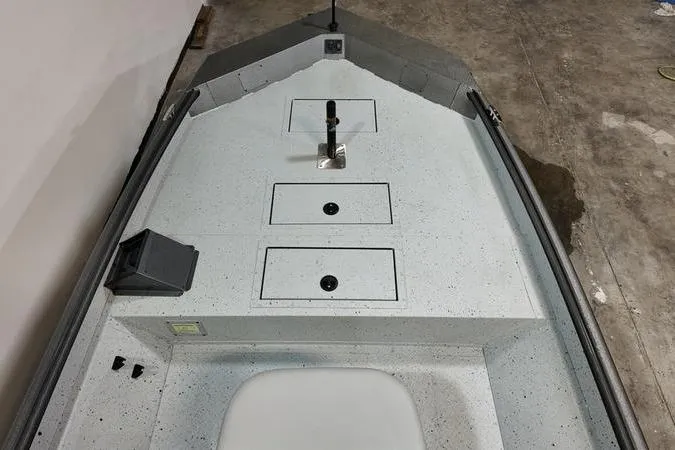 Slide: The Image of 2025 SeaArk Shadow 18T boat interior with storage compartments and a clean, speckled deck. - 14