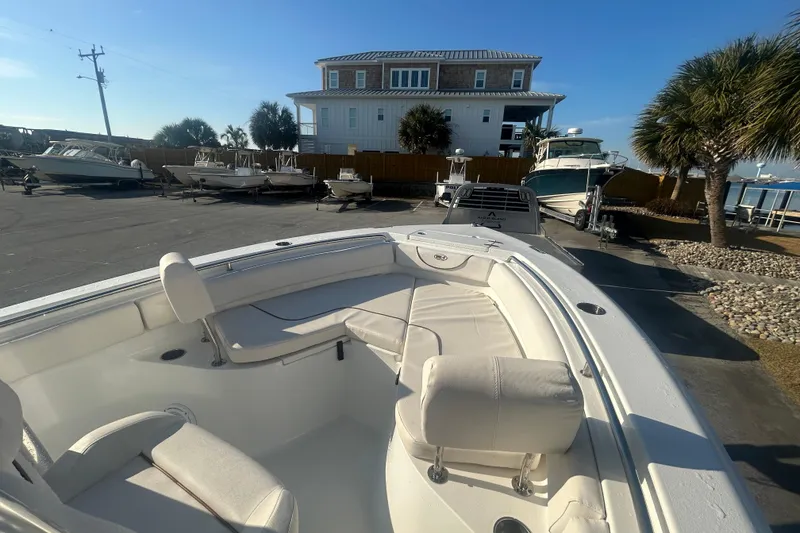 Slide: The Image of 2019 Sea Hunt Ultra 211 boat parked near waterfront, surrounded by other boats and palm trees. - 22