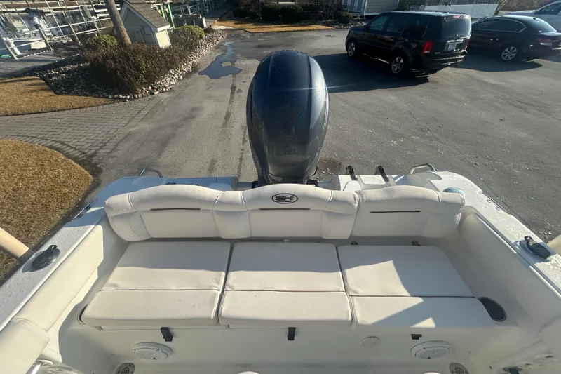 Slide: The Image of 2019 Sea Hunt Ultra 211 boat with cushioned seating and outboard motor. - 7