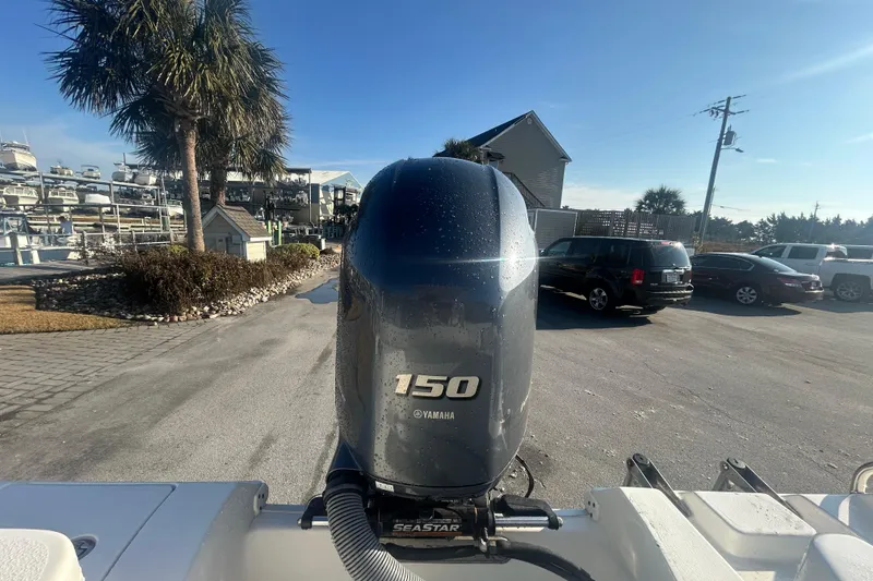 Slide: The Image of 2019 Sea Hunt Ultra 211 with Yamaha 150 engine in a marina setting. - 9