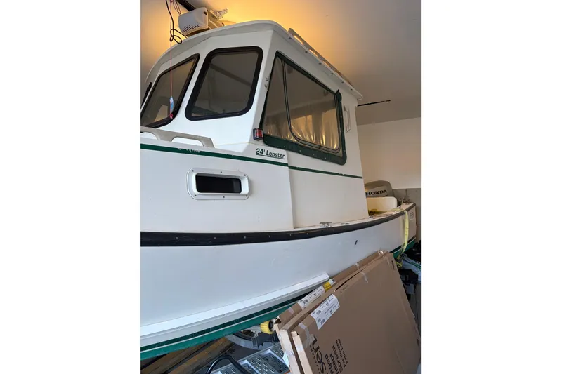 The Image of 2007 Eastern 24 Lobster boat in a garage, partially visible with a Honda engine. - 1