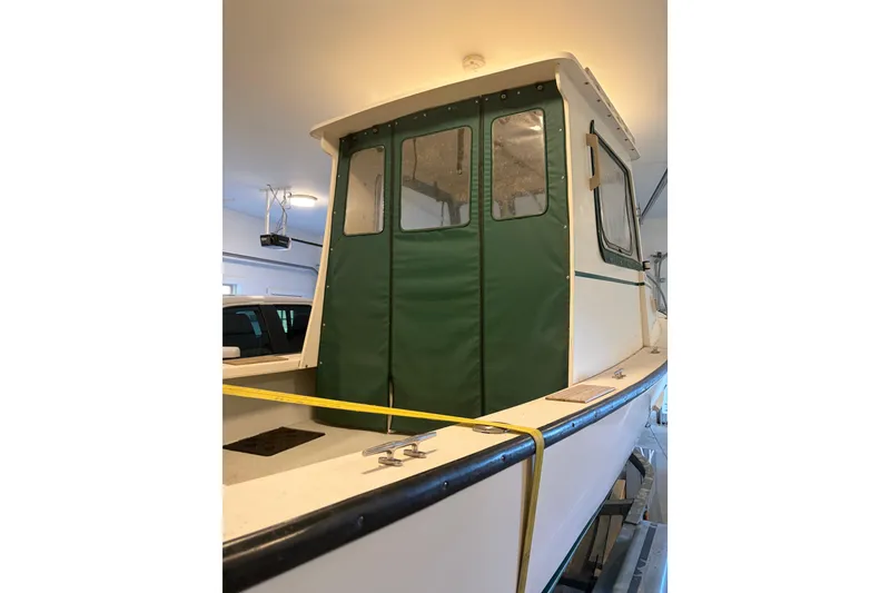 Slide: The Image of 2007 Eastern 24 Lobster boat with green canvas cover in a garage. - 5