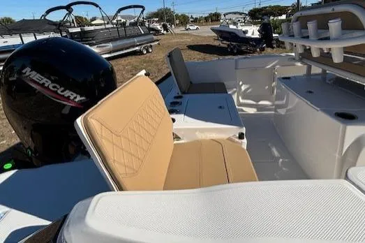 Slide: The Image of 2026 Bayliner Trophy T20CC boat interior with tan seating and Mercury engine. - 10