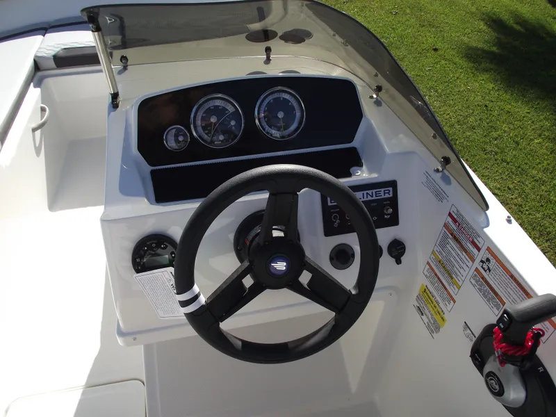 Slide: The Image of 2024 Bayliner Element M19 boat dashboard with steering wheel and gauges. - 17