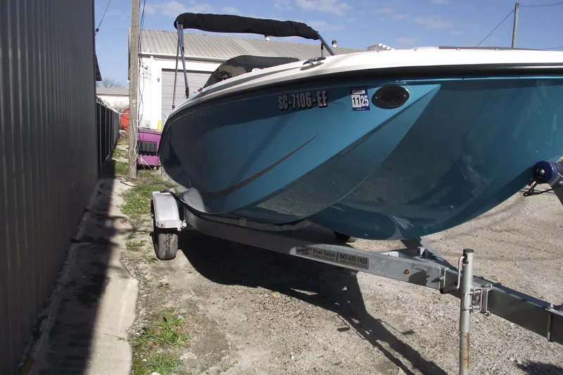 Slide: The Image of 2024 Bayliner Element M19 boat on trailer, parked outdoors. - 2