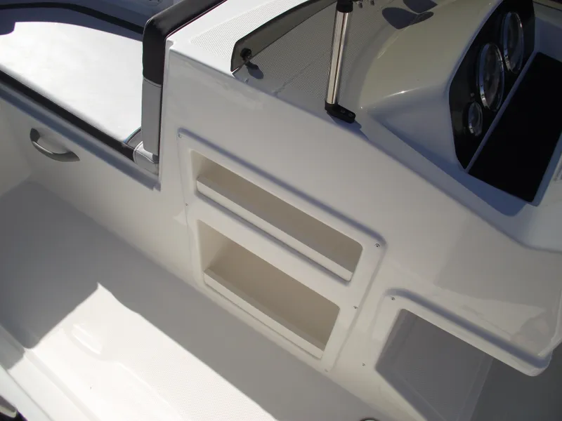 Slide: The Image of 2024 Bayliner Element M19 boat interior with storage compartments and dashboard. - 22