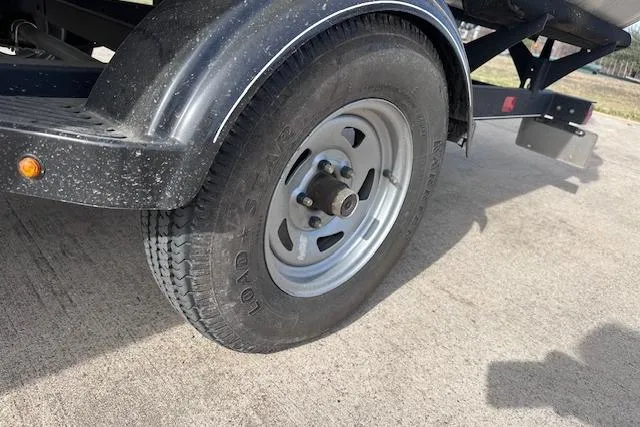 Slide: The Image of Trailer wheel of a 2020 Sun Tracker Bass Buggy 16 DLX on concrete surface. - 23