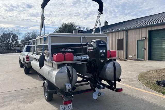 Slide: The Image of 2020 Sun Tracker Bass Buggy 16 DLX pontoon boat on trailer, parked outdoors. - 3