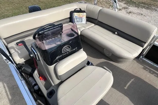 Slide: The Image of 2020 Sun Tracker Bass Buggy 16 DLX pontoon boat interior with beige seating and steering console. - 9