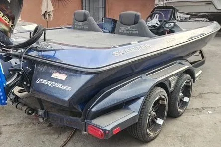 Slide: The Image of 2018 Skeeter FX21 Limited Edition boat with dual axle trailer, parked outdoors. - 1