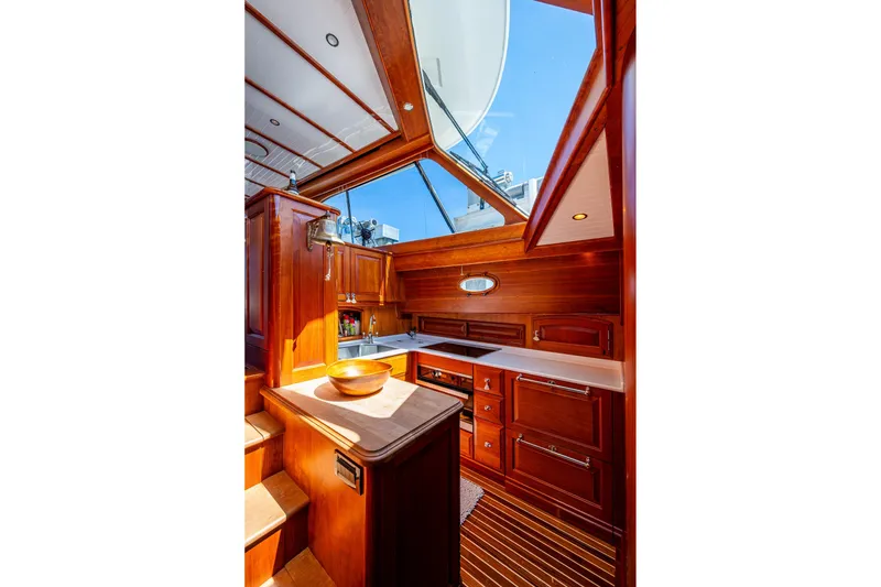 Slide: The Image of Luxurious 2021 Hinckley Talaria yacht interior with elegant wood cabinetry and skylight. - 20