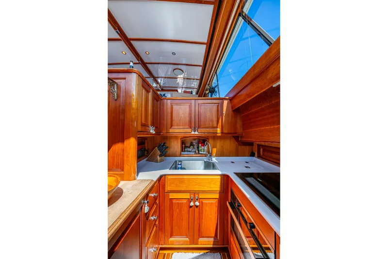 Slide: The Image of Luxurious 2021 Hinckley Talaria yacht kitchen with elegant wood cabinetry and modern appliances. - 21