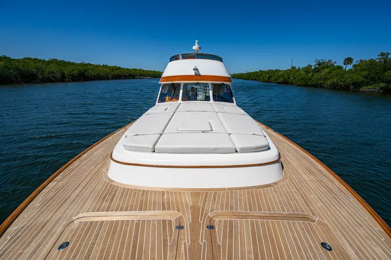 Slide: The Image of 2021 Hinckley Talaria yacht cruising on a serene river with clear blue skies. - 3