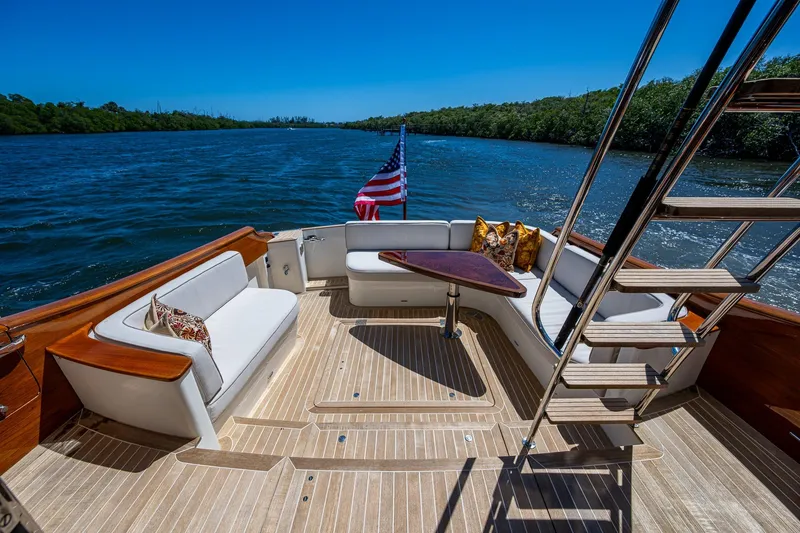 Slide: The Image of Luxury 2021 Hinckley Talaria yacht deck with seating, table, and American flag. - 7