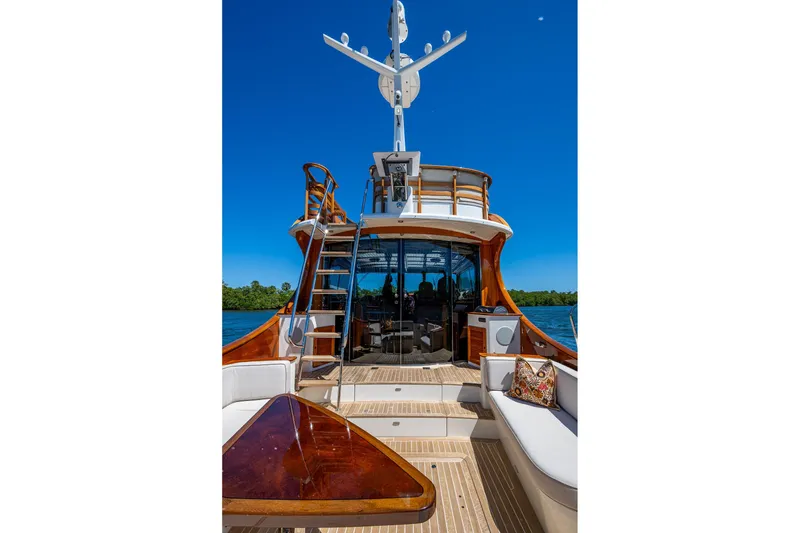 Slide: The Image of 2021 Hinckley Talaria yacht with elegant deck and seating, under clear blue sky. - 9