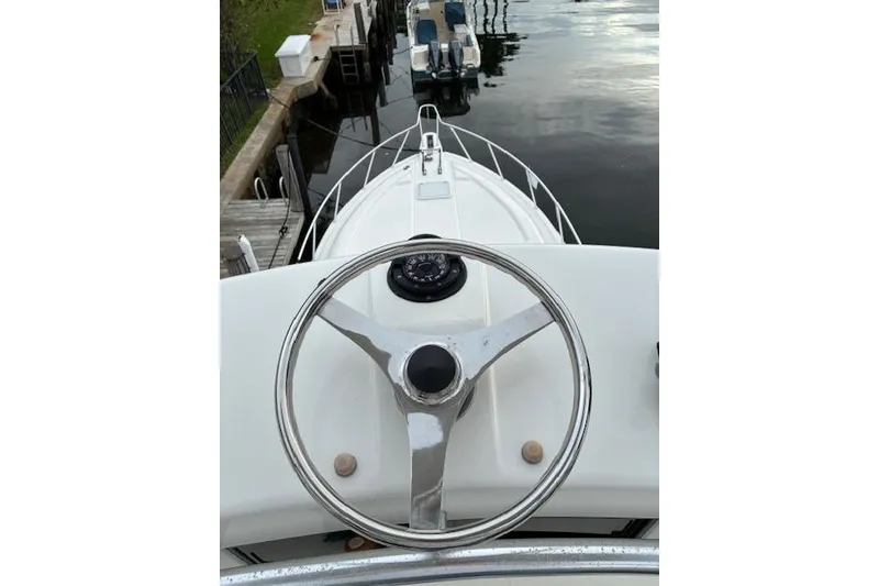 Slide: The Image of Steering wheel view from a 2007 Bertram 360 yacht docked at a marina. - 11