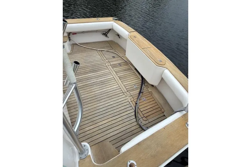 Slide: The Image of 2007 Bertram 360 boat deck with wooden flooring and railing, docked by the water. - 13