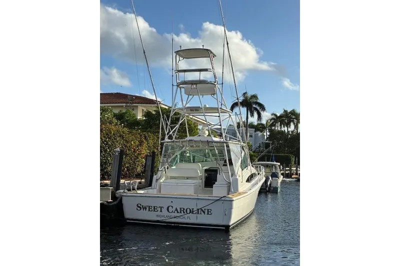Slide: The Image of 2007 Bertram 360 boat named "Sweet Caroline" docked in a sunny marina. - 2